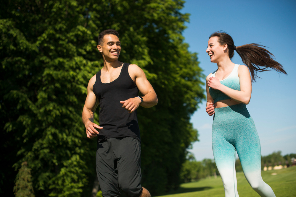 Hombre y mujer felices corriendo al aire libre.