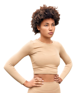 Mujer con camiseta de pilates beige de pie. Fondo blanco.